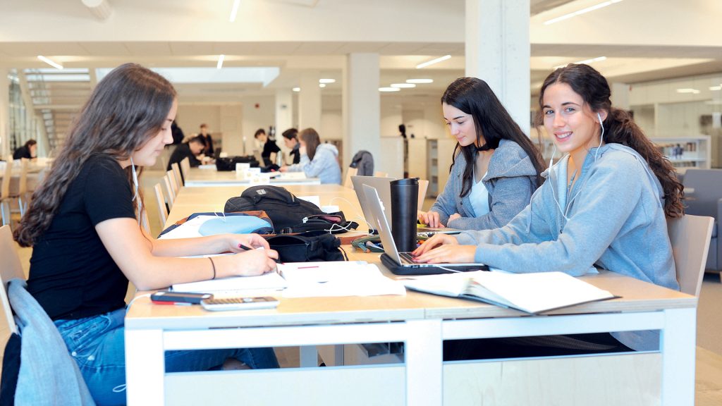Trois étudiantes révisant à la bibliothèque