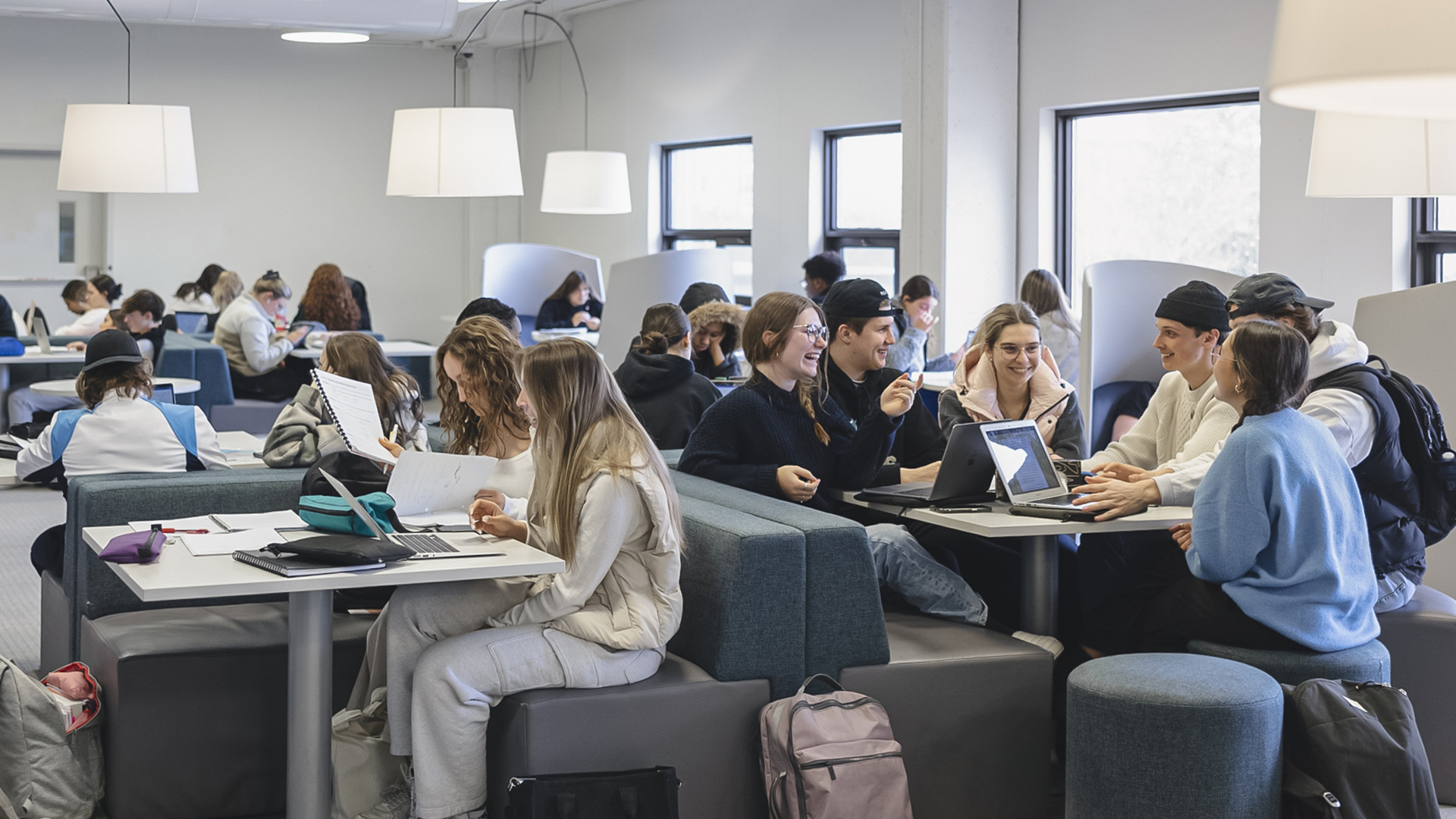 Groupes d'étudiants travaillant et discutant dans l'Espace collaboratif